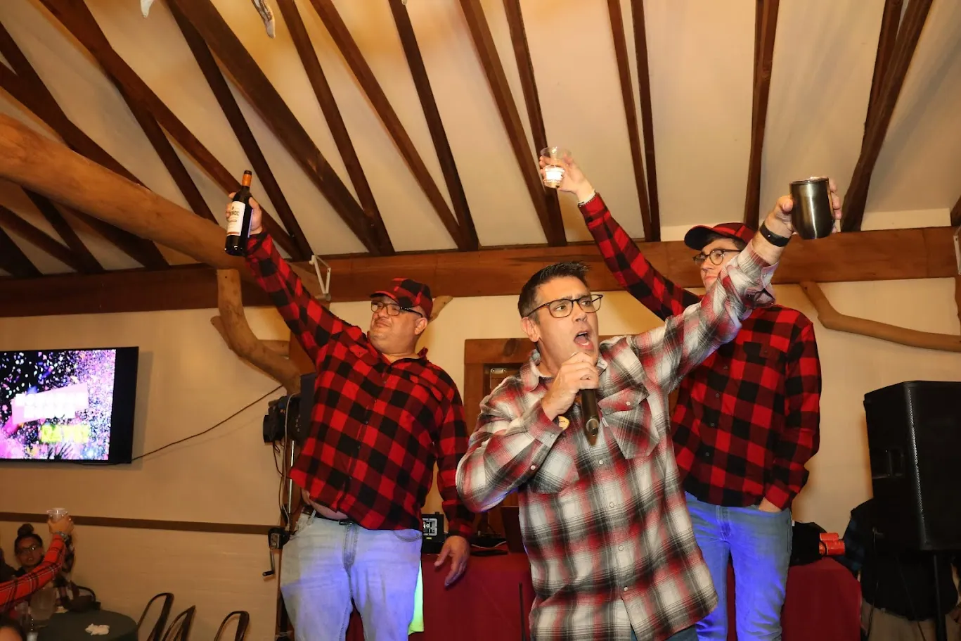 Guests in plaid flannel shirts singing karaoke in the lodge