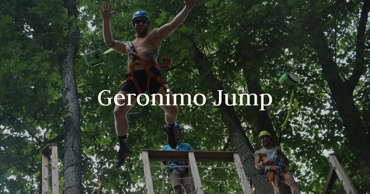 A guest stands on top of a tall pole before the Geronimo Jump