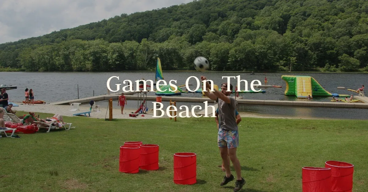 Guests play giant beach games with red buckets on the sand