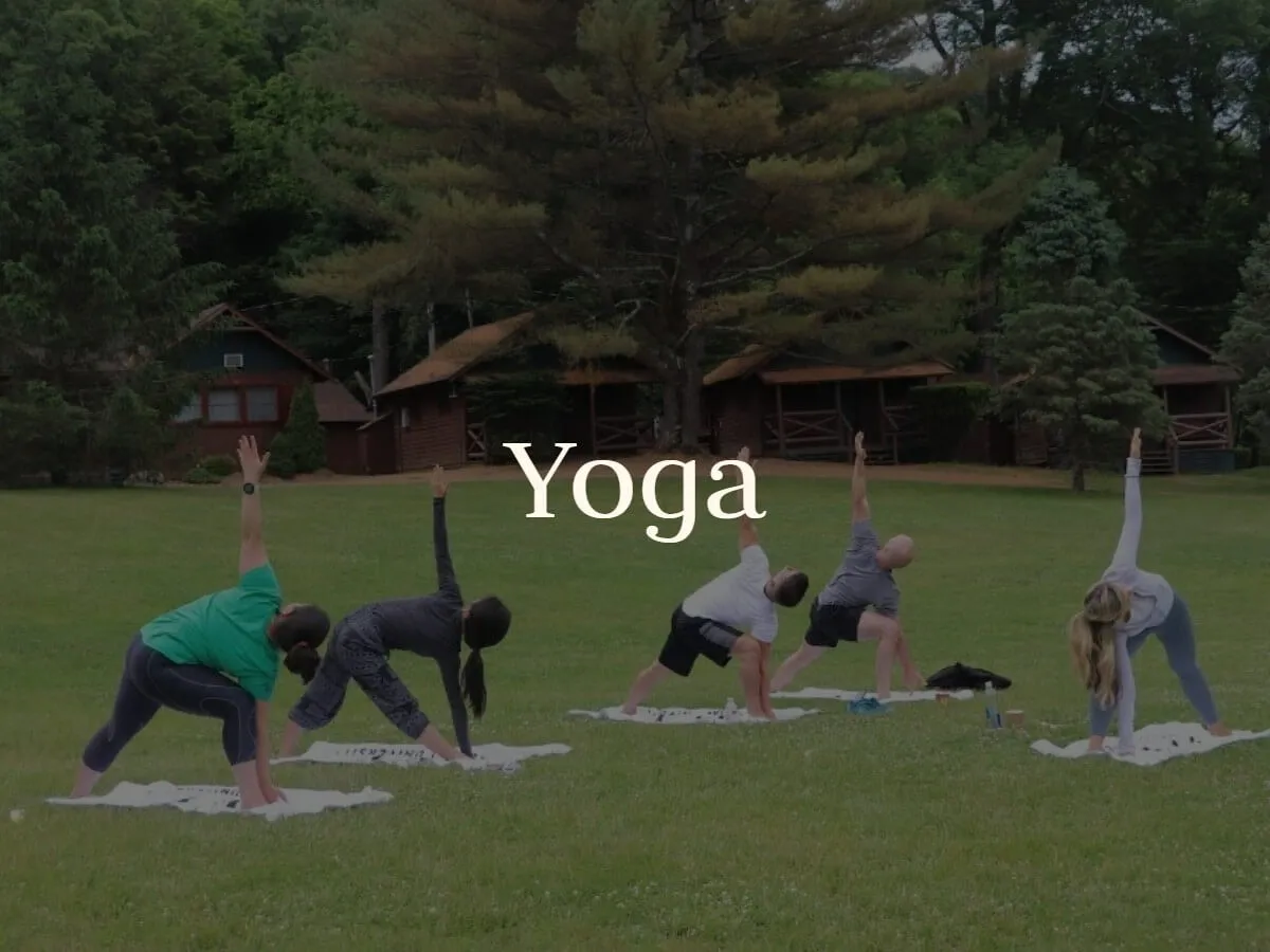 Guests stretch through a yoga class on the grass
