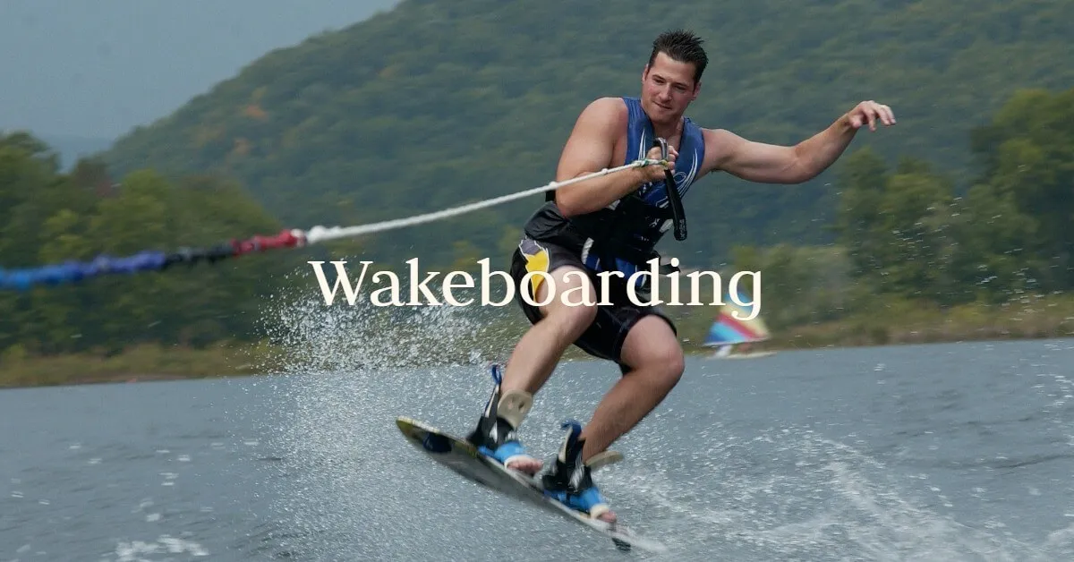 A wakeboarder carves across the lake behind the boat