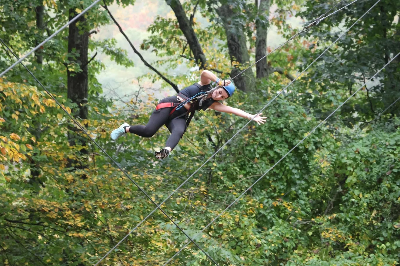 Woman zip-lining through the trees
