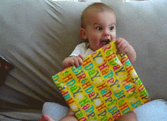 Baby happily tearing into a birthday-wrapped present