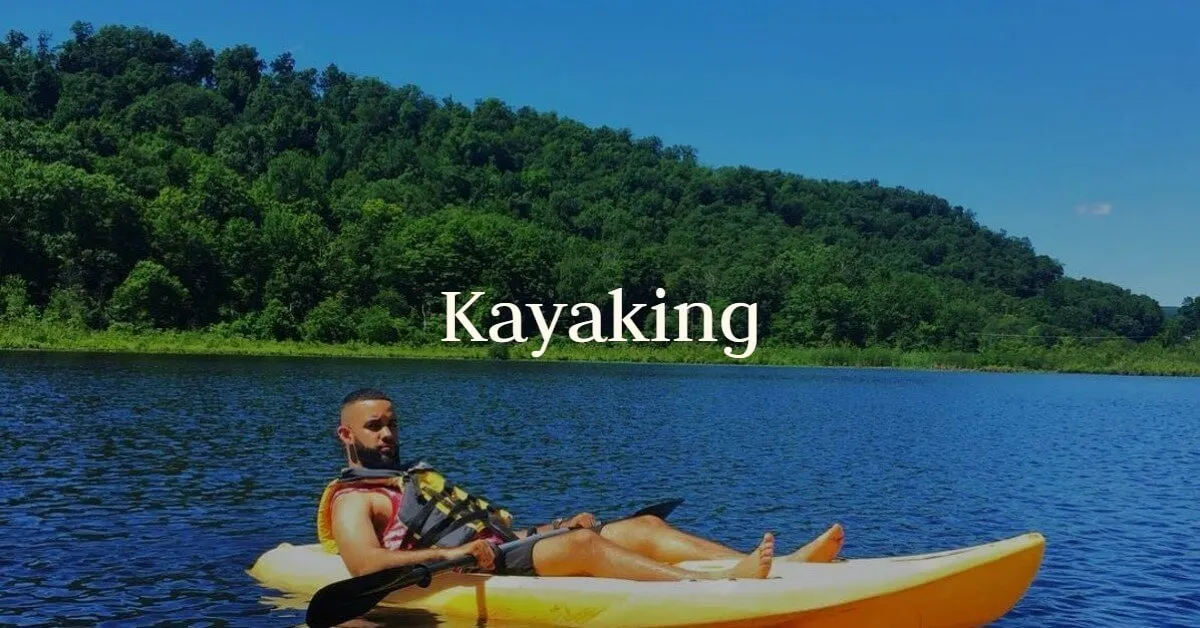 A guest relaxes in a yellow kayak on the lake